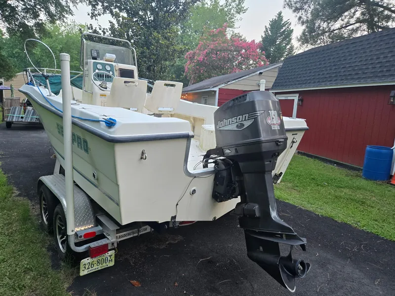 Slide: The Image of A 1999 Sea Pro 210 Center Console boat on a trailer in a driveway. - 2