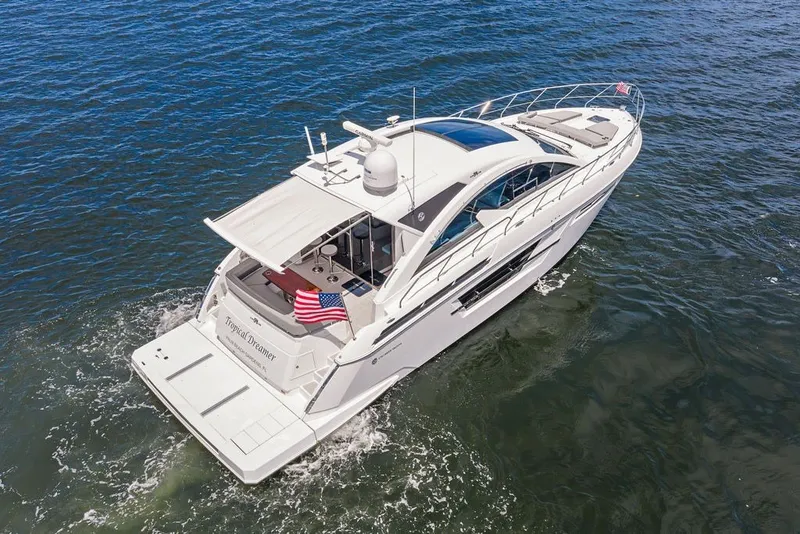 Slide: The Image of 2022 Cruisers Yachts 54 Cantius cruising on open water, rear view. - 14