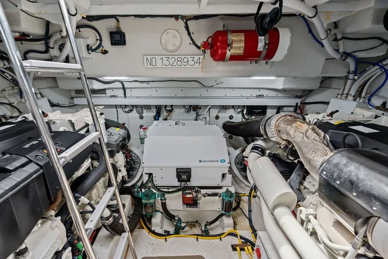 Slide: The Image of Engine room of 2022 Cruisers Yachts 54 Cantius, featuring modern equipment and fire extinguisher. - 75