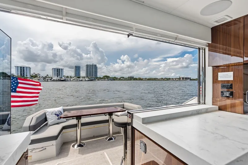 Slide: The Image of Luxurious 2022 Cruisers Yachts 54 Cantius interior with waterfront view and American flag. - 34