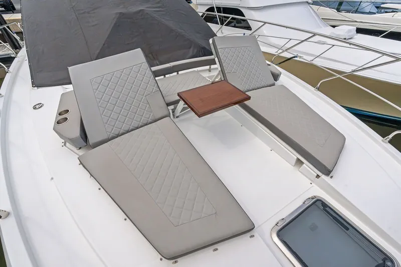 Slide: The Image of Luxurious 2022 Cruisers Yachts 54 Cantius with elegant sun loungers and table on deck. - 23