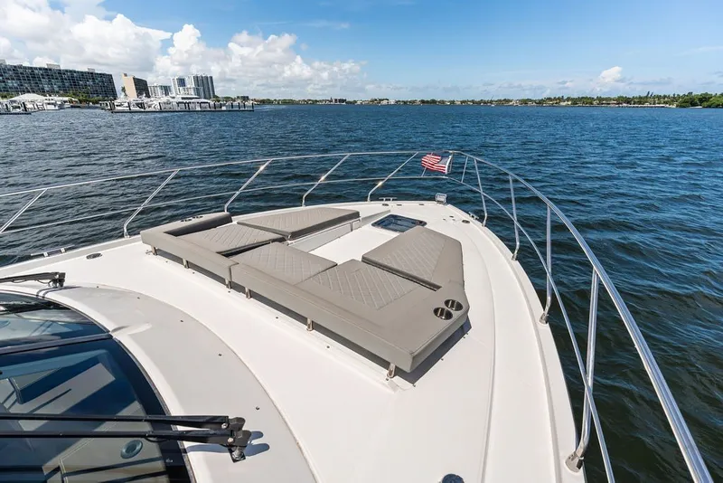Slide: The Image of 2022 Cruisers Yachts 54 Cantius on water, featuring spacious deck and sun loungers. - 20