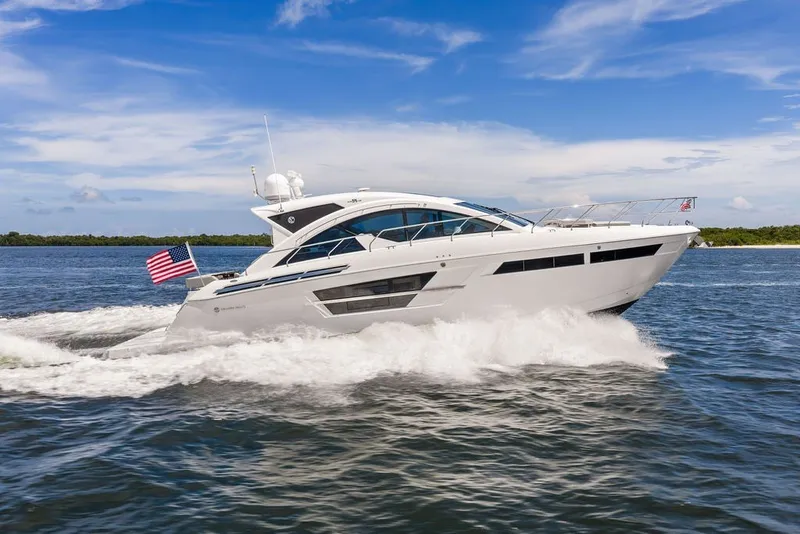 Slide: The Image of 2022 Cruisers Yachts 54 Cantius cruising on open water under a clear blue sky. - 17