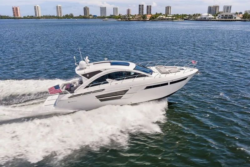 Slide: The Image of 2022 Cruisers Yachts 54 Cantius cruising on water with city skyline in background. - 19