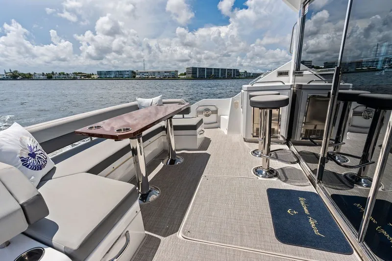 Slide: The Image of Luxurious 2022 Cruisers Yachts 54 Cantius deck with seating and scenic water view. - 30