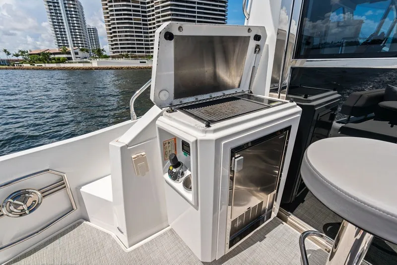 Slide: The Image of Outdoor kitchen area on 2022 Cruisers Yachts 54 Cantius, featuring grill and refrigerator. - 32