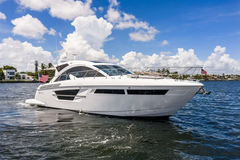 Slide: The Image of 2022 Cruisers Yachts 54 Cantius on water, under clear blue sky. - 16