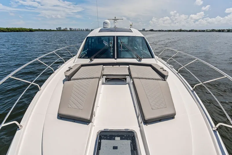 Slide: The Image of 2022 Cruisers Yachts 54 Cantius luxury yacht with sunbathing deck on open water. - 22