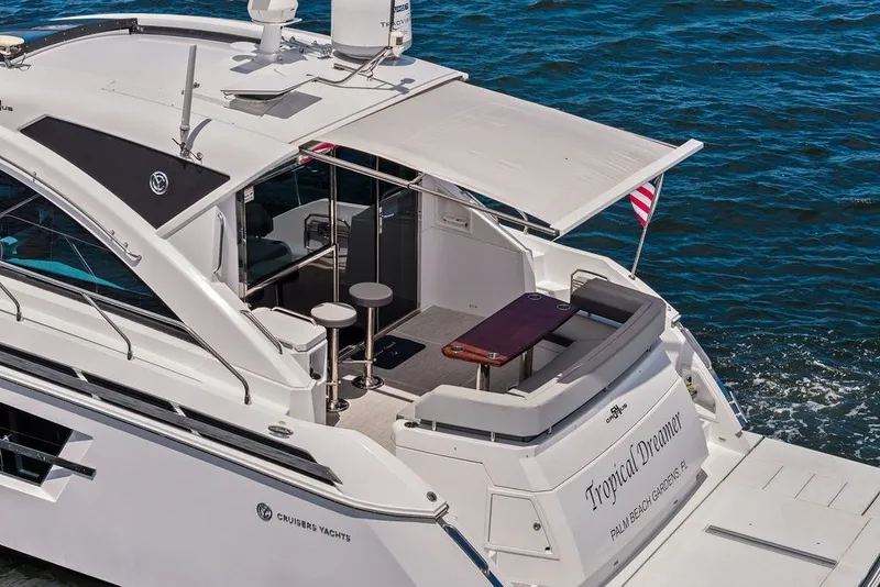 Slide: The Image of 2022 Cruisers Yachts 54 Cantius on water, featuring spacious deck and seating area. - 13
