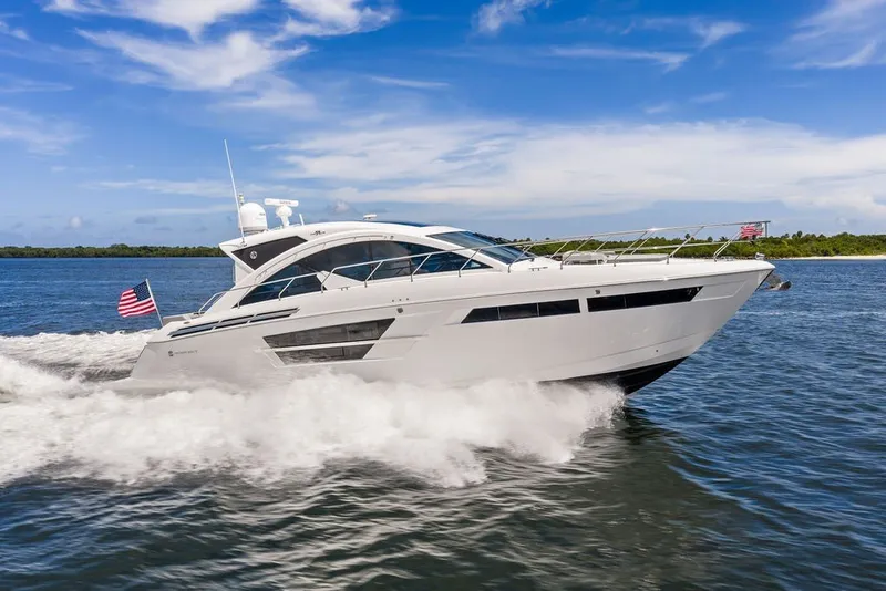 Slide: The Image of 2022 Cruisers Yachts 54 Cantius cruising on open water under a clear blue sky. - 18