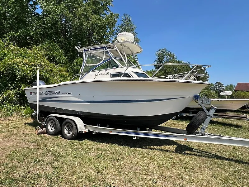 The Image of A white 1990 Hydra-Sports Vector 2200 DC boat on a trailer outdoors. - 0