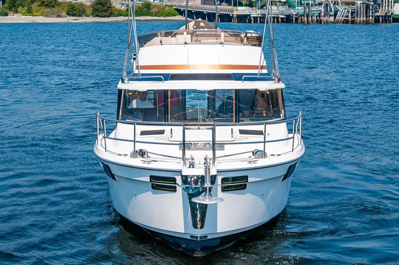 Slide: The Image of 2020 Ranger Tugs R-41 CB yacht cruising on blue water near a dock. - 4