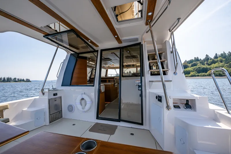 Slide: The Image of 2020 Ranger Tugs R-41 CB boat interior with open cabin door and scenic water view. - 17