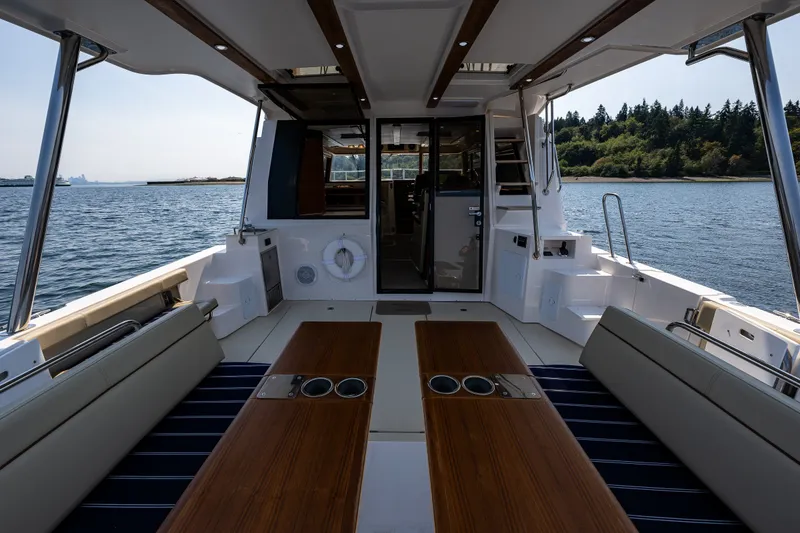 Slide: The Image of 2020 Ranger Tugs R-41 CB boat interior with seating and table on open water. - 14