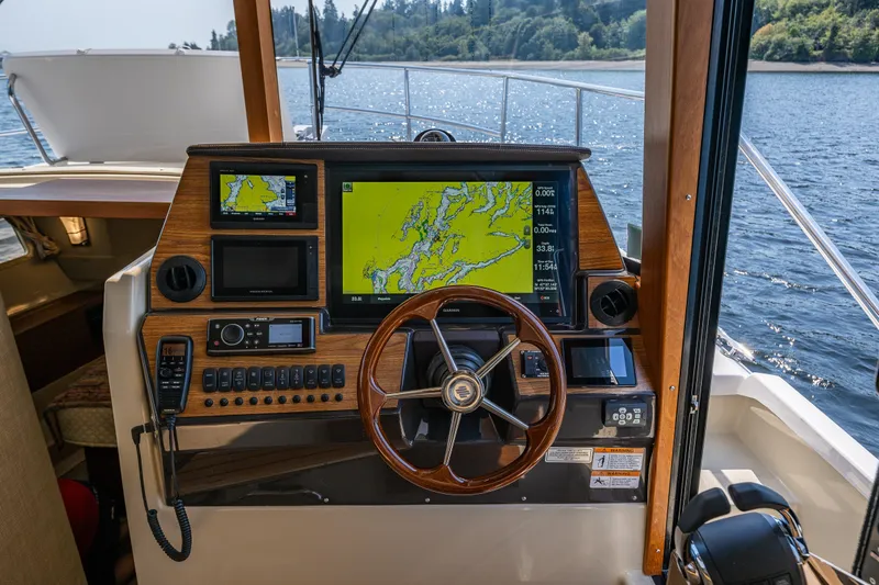 Slide: The Image of 2020 Ranger Tugs R-41 CB helm with navigation screens and wooden steering wheel. - 27