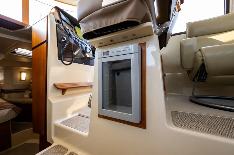 Slide: The Image of Interior of 2020 Ranger Tugs R-41 CB boat, featuring seating and a compact refrigerator. - 26