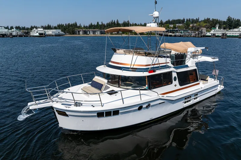 Slide: The Image of 2020 Ranger Tugs R-41 CB yacht on calm water, featuring a spacious deck and modern design. - 1