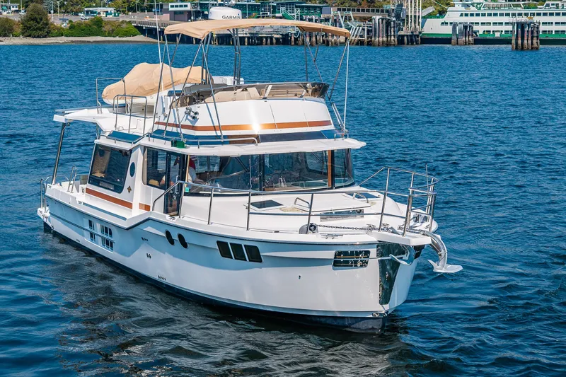 Slide: The Image of 2020 Ranger Tugs R-41 CB yacht cruising on blue water near a harbor. - 3