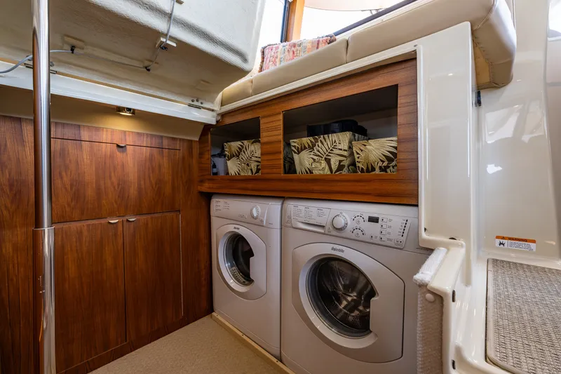 Slide: The Image of Laundry area inside 2020 Ranger Tugs R-41 CB boat with wood cabinetry and appliances. - 39
