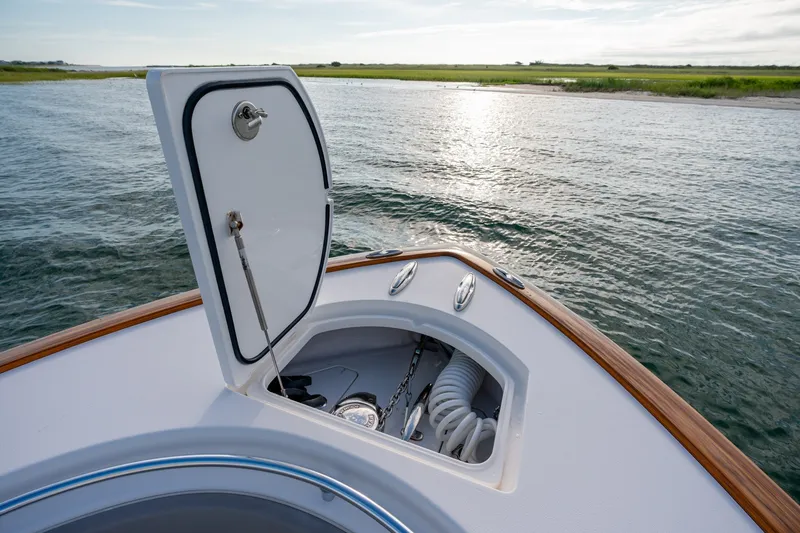 Slide: The Image of Open anchor hatch on 2021 Valhalla V-33 boat, near serene shoreline. - 26