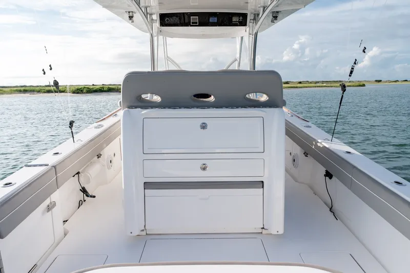 Slide: The Image of Valhalla V-33 2021 boat interior with storage drawers, fishing rods, and ocean view. - 17