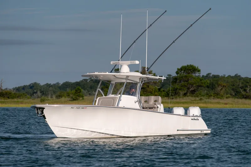 Slide: The Image of 2021 Valhalla V-33 boat cruising on a serene lake with fishing rods. - 1