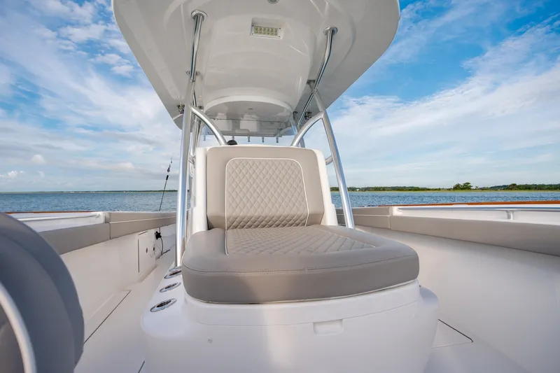 Slide: The Image of 2021 Valhalla V-33 boat interior with cushioned seating, overlooking serene water and blue sky. - 28