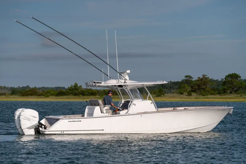 Slide: The Image of 2021 Valhalla V-33 boat cruising on a calm lake with fishing rods. - 5
