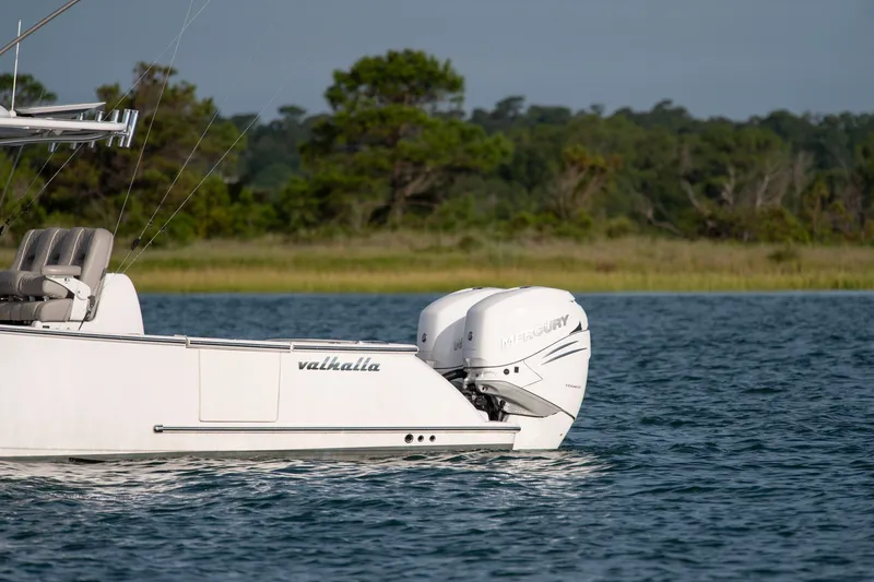 Slide: The Image of 2021 Valhalla V-33 boat with Mercury engines on a serene lake. - 44