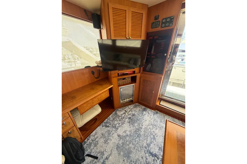 Slide: The Image of Interior of 2002 Seahorse 45 MY yacht with TV, wooden cabinetry, and carpeted floor. - 25