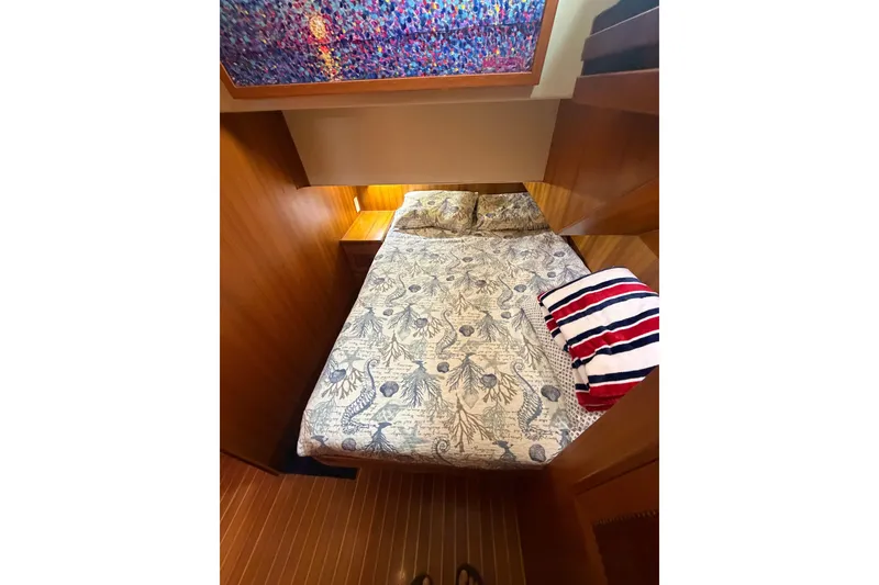 Slide: The Image of Cozy cabin interior of 2002 Seahorse 45 MY yacht with patterned bedding and striped pillow. - 21