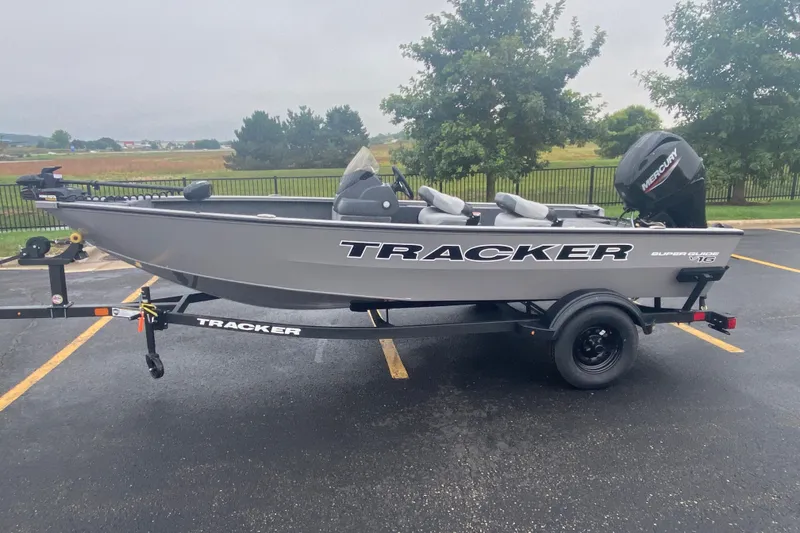 The Image of 2027 Tracker Super Guide V-16 SC fishing boat on trailer in parking lot. - 0