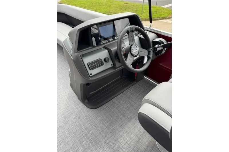 Slide: The Image of 2027 Sun Tracker Party Barge 18 DLX steering console with modern controls and seating. - 15