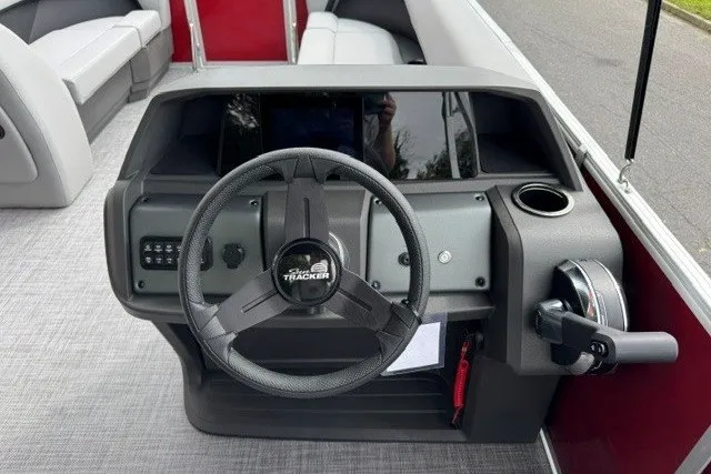 Slide: The Image of 2027 Sun Tracker Party Barge 18 DLX steering console with modern controls and seating. - 13