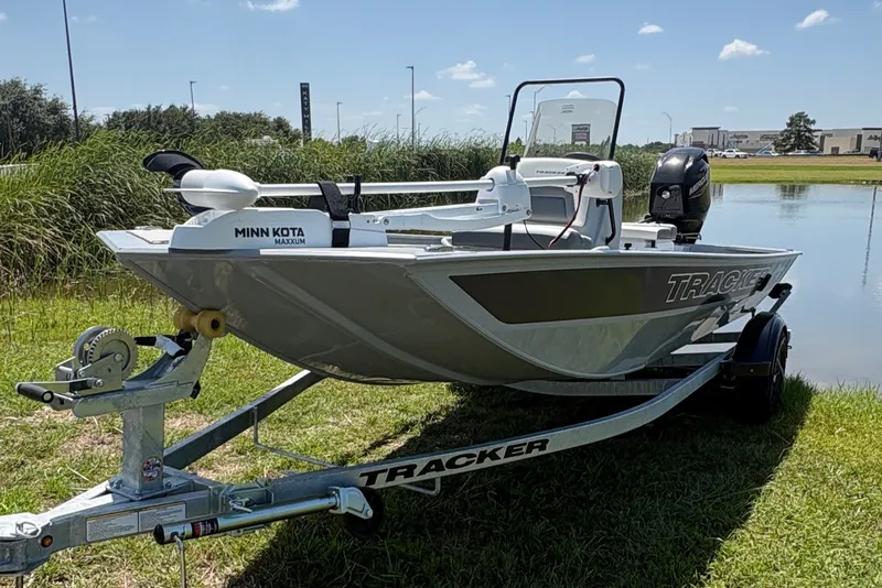 The Image of 2027 Tracker Bass Tracker Classic CC boat on trailer by a lake under clear sky. - 0