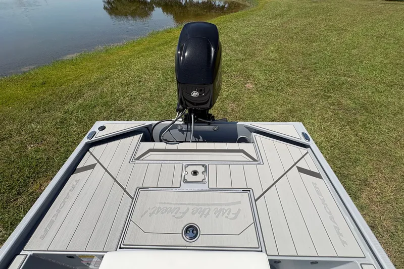 Slide: The Image of 2027 Tracker Bass Tracker Classic CC boat on grassy shore near water. - 18
