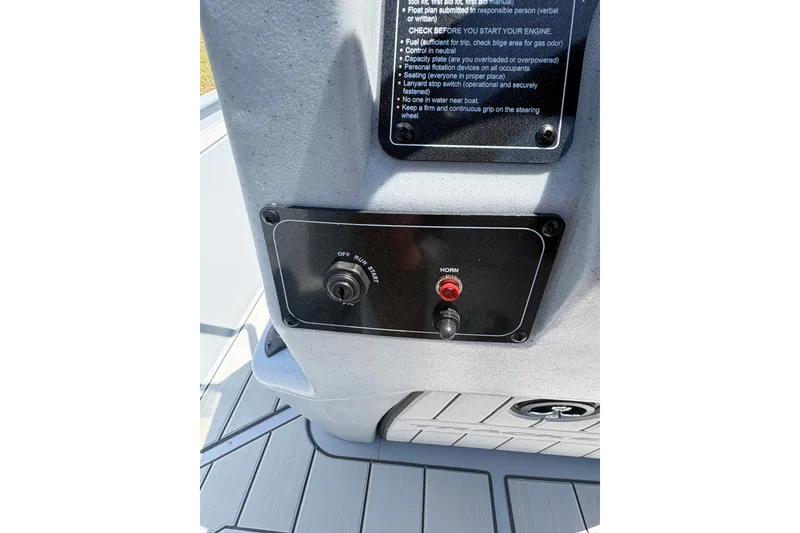 Slide: The Image of Control panel of 2027 Tracker Bass Tracker Classic CC boat with ignition and horn buttons. - 14