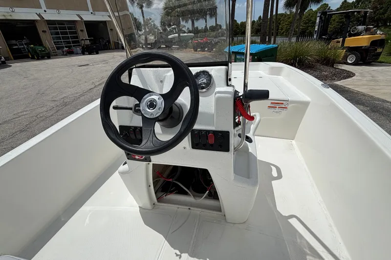 Slide: The Image of 2027 Mako Pro Skiff 17 CC boat interior with steering wheel and control panel. - 11