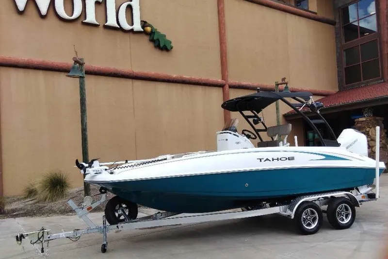 The Image of 2027 Tahoe 2150 CC boat on trailer outside a building. - 0