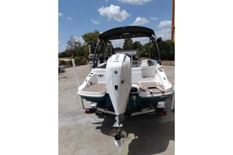 Slide: The Image of 2027 Tahoe 2150 CC boat, rear view with outboard motor, parked outdoors. - 10