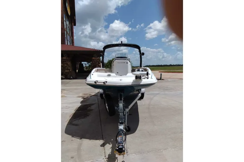 Slide: The Image of 2027 Tahoe 2150 CC boat on trailer, parked outdoors under a cloudy sky. - 2