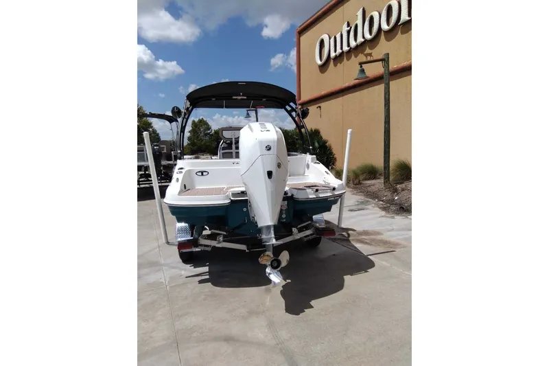 Slide: The Image of 2027 Tahoe 2150 CC boat with outboard motor, parked outdoors under a clear sky. - 11