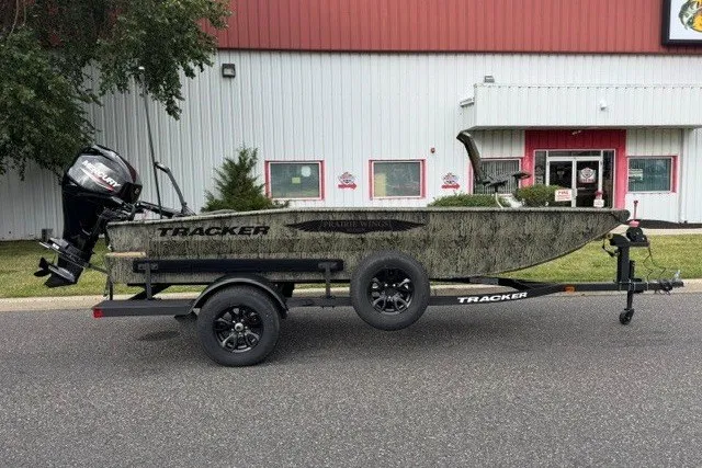 The Image of 2027 Tracker Grizzly 1650 T Prairie Wings Edition boat on trailer, parked outside a building. - 0