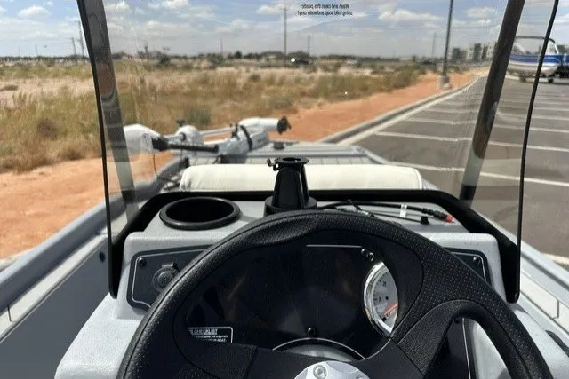 Slide: The Image of 2027 Tracker Bass Tracker Classic CC boat dashboard with steering wheel and controls. - 14