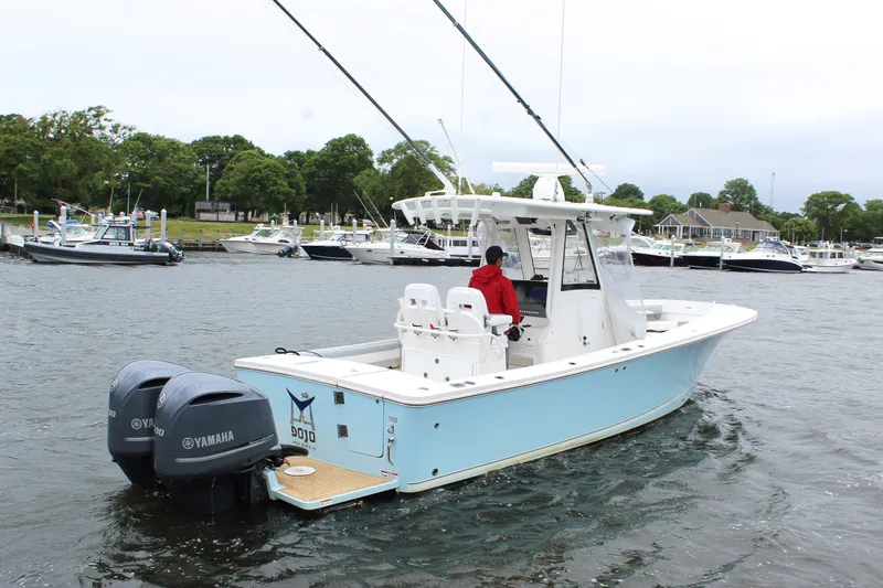 Slide: The Image of 2020 Regulator 28 Forward Seating boat with dual Yamaha engines on a calm waterway. - 4