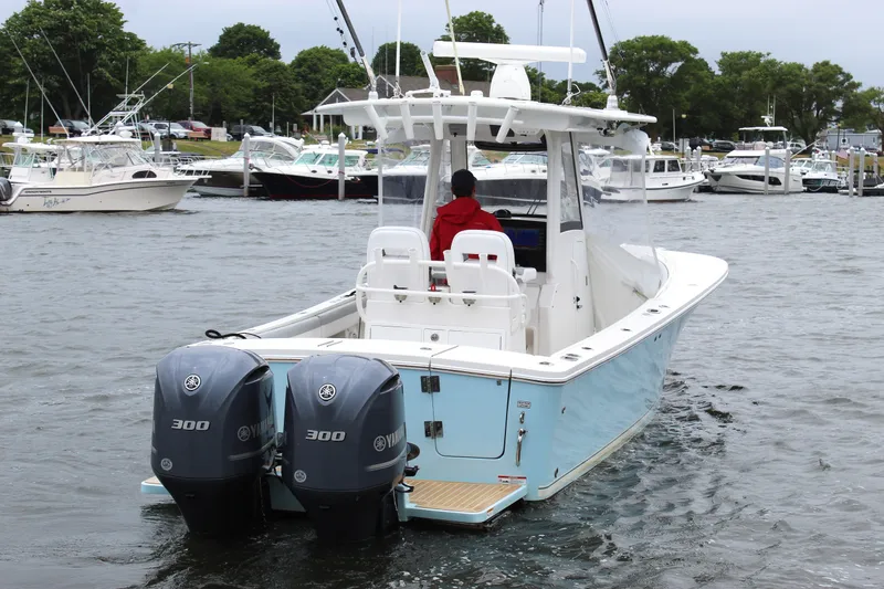 Slide: The Image of 2020 Regulator 28 Forward Seating boat with dual Yamaha engines in a marina. - 8