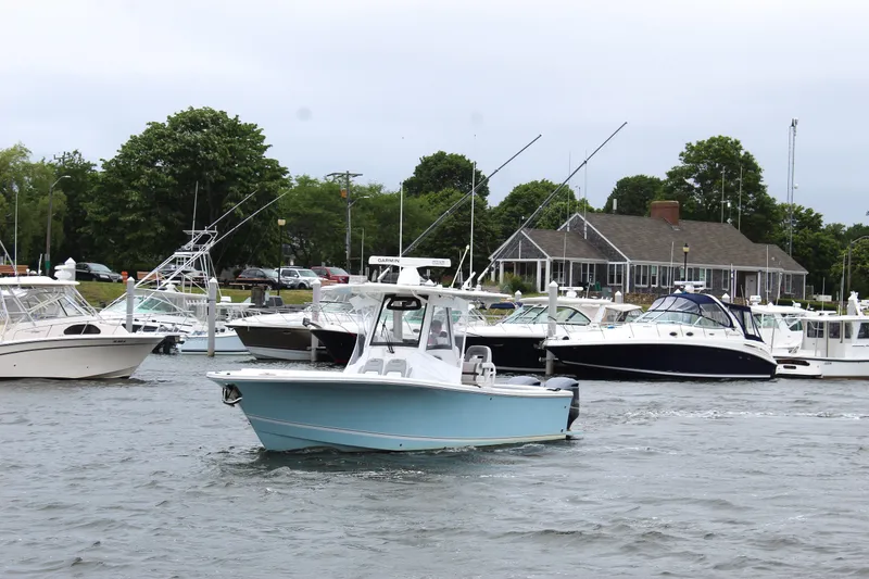 Slide: The Image of 2020 Regulator 28 Forward Seating boat in a marina with other vessels. - 1
