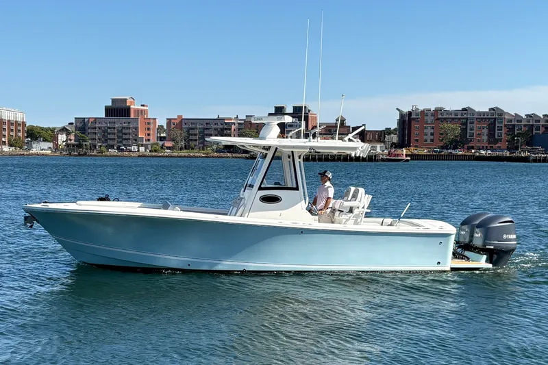 The Image of 2020 Regulator 28 Forward Seating boat cruising on water near urban skyline. - 0