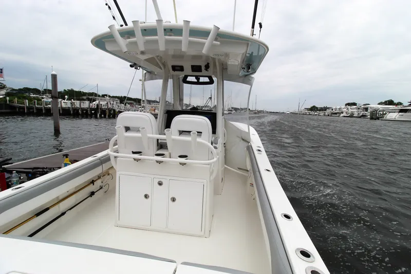 Slide: The Image of 2020 Regulator 28 Forward Seating boat on water near marina docks. - 20