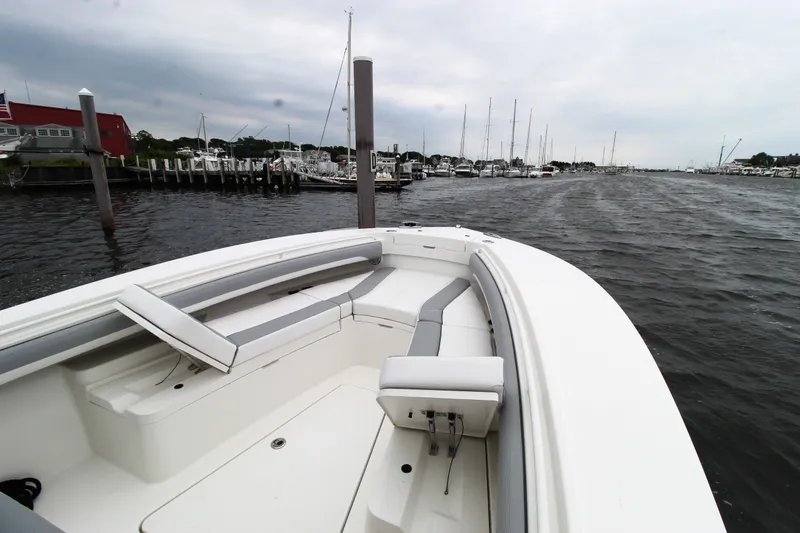 Slide: The Image of 2020 Regulator 28 Forward Seating boat docked at a marina on a cloudy day. - 13